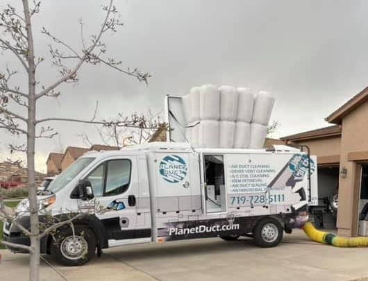 Planet Duct white truck parked in front of a house in Colorado Springs.