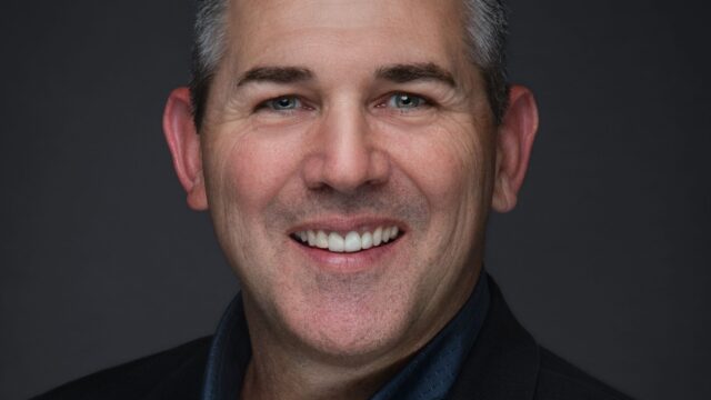 Steve Fisher of Heartland representing the Pikes Peak Pros Business Networking Group in Colorado Springs, wearing a black suit and blue shirt.