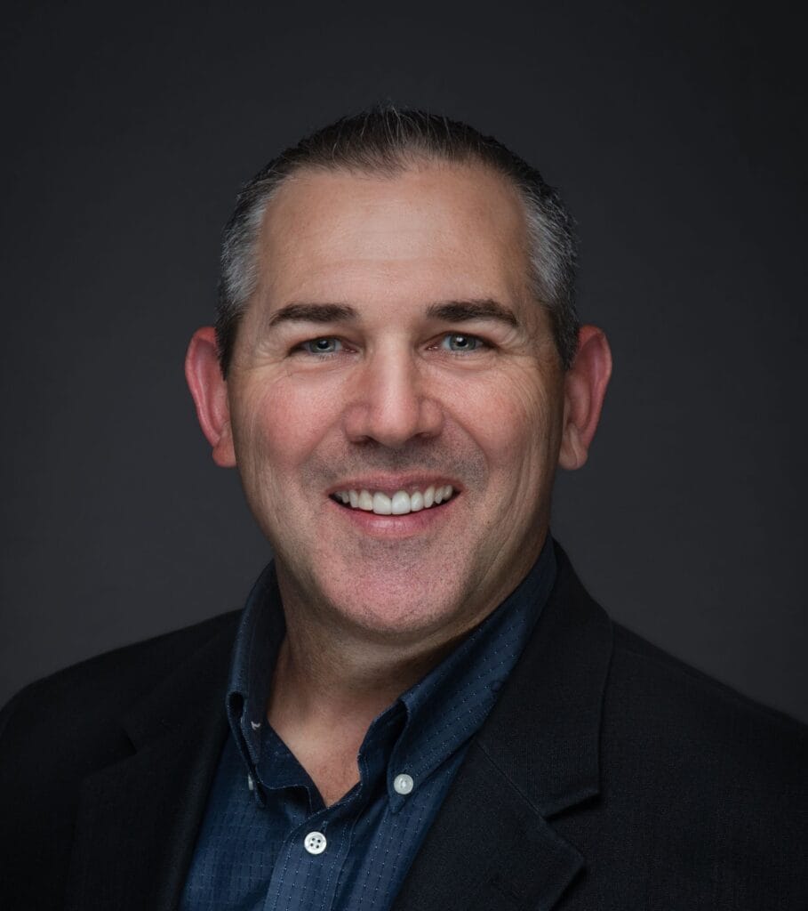 Steve Fisher of Heartland representing the Pikes Peak Pros Business Networking Group in Colorado Springs, wearing a black suit and blue shirt.