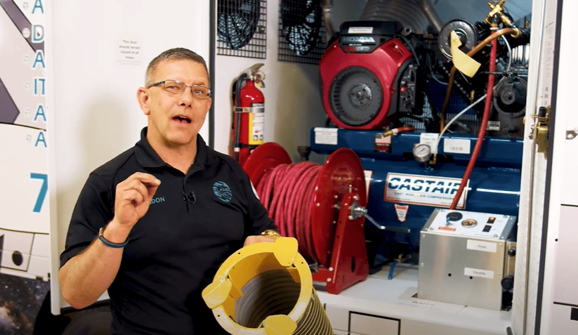 Brandon Kirk from the Pikes Peak Pros Business Networking Group is pictured in front of a hose machine in Colorado Springs.