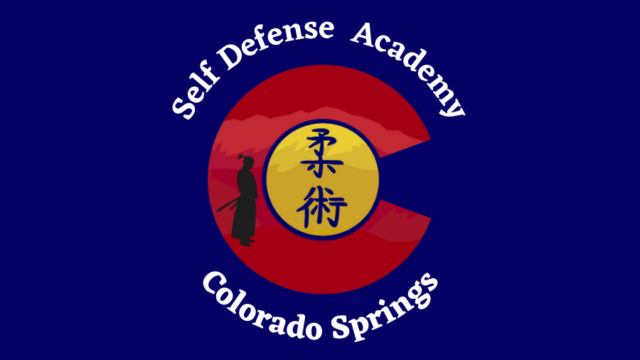 Logo of self defense academy, colorado springs, featuring a red circle, a yellow yin-yang symbol, and a silhouette of a martial artist.